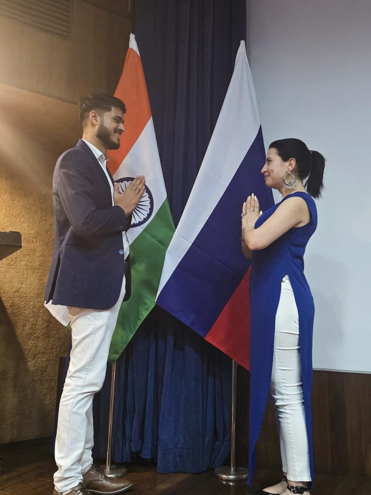 Akshat Mehrotra and a female dignitary greeting each other with Namaste.